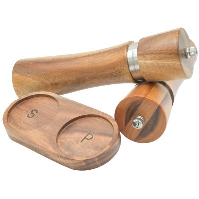 Handcrafted acacia wood salt and pepper grinders with ceramic mechanisms, displayed on a matching wooden tray with natural grain visible.