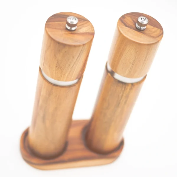 Handcrafted acacia wood salt and pepper grinders with ceramic mechanisms, displayed on a matching wooden tray with natural grain visible.