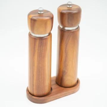 Acacia wood salt and pepper grinders with ceramic grinding cores, displayed on a matching wooden base.